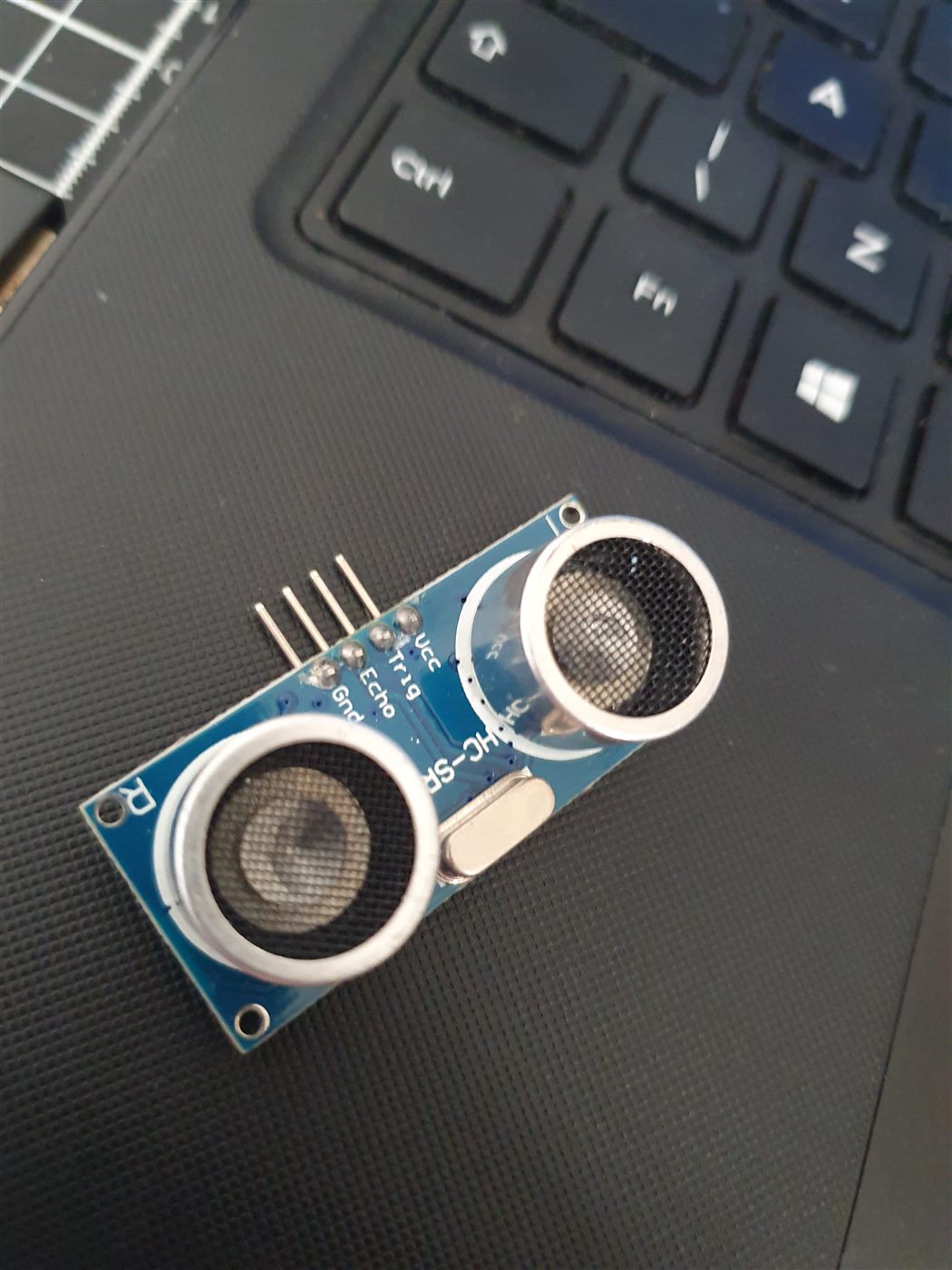 Sensor ultrassônico HC-SR04 com os pinos Vcc, Trig, Echo e Gnd identificados na plaquinha